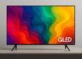 Samsung QLED TV on a stand displaying a vibrant multicolor abstract pattern with thin bezels and modern design.