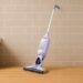 Shark VacMop 2‑in‑1 cordless vacuum spray mop standing against a kitchen wall