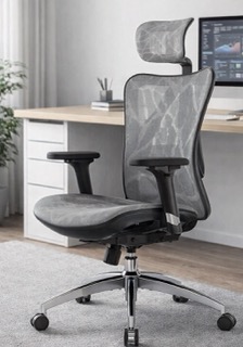 SIHOO M57 ergonomic office chair positioned in front of a modern desk, showcasing its grey mesh backrest, adjustable headrest, and chrome base in a bright home office setting.