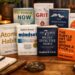 A collection of popular self-development books arranged neatly on a wooden table with warm lighting.
